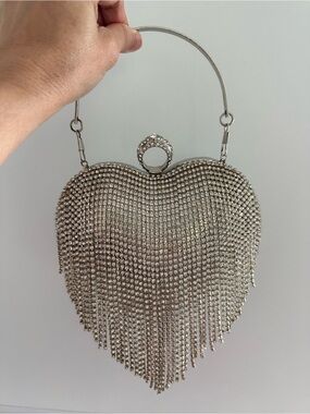Heart-shaped silver handbag with sparkling stones, handbag and crossbody strap.